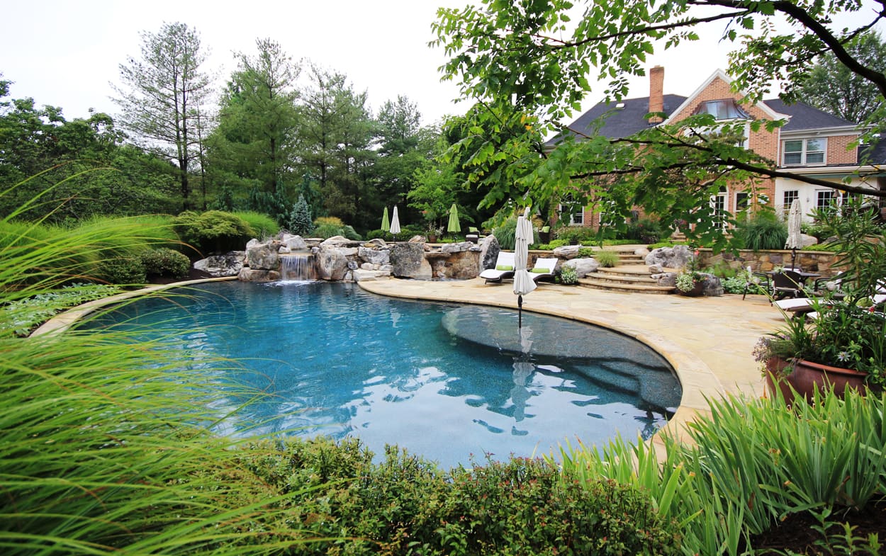 01curvedswimmingpooldesignwithbuiltinumbrellastand Surrounds