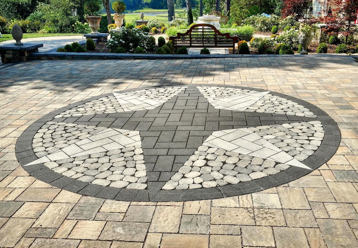 paver backyard patio design with ornate inlay and border