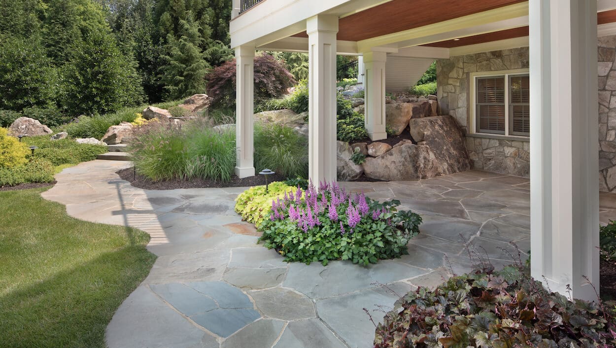flagstone backyard patio design with custom curving edges and mortared joints