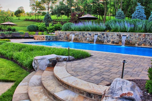 swimming pool with water spouts retaining wall