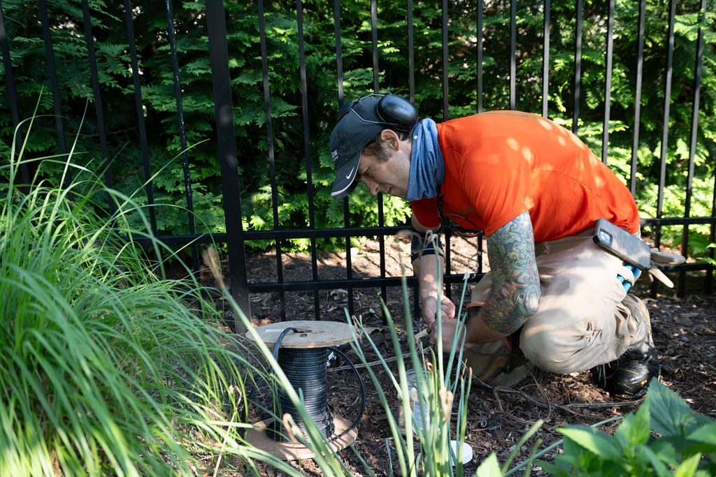 landscape technician installing lighting wire