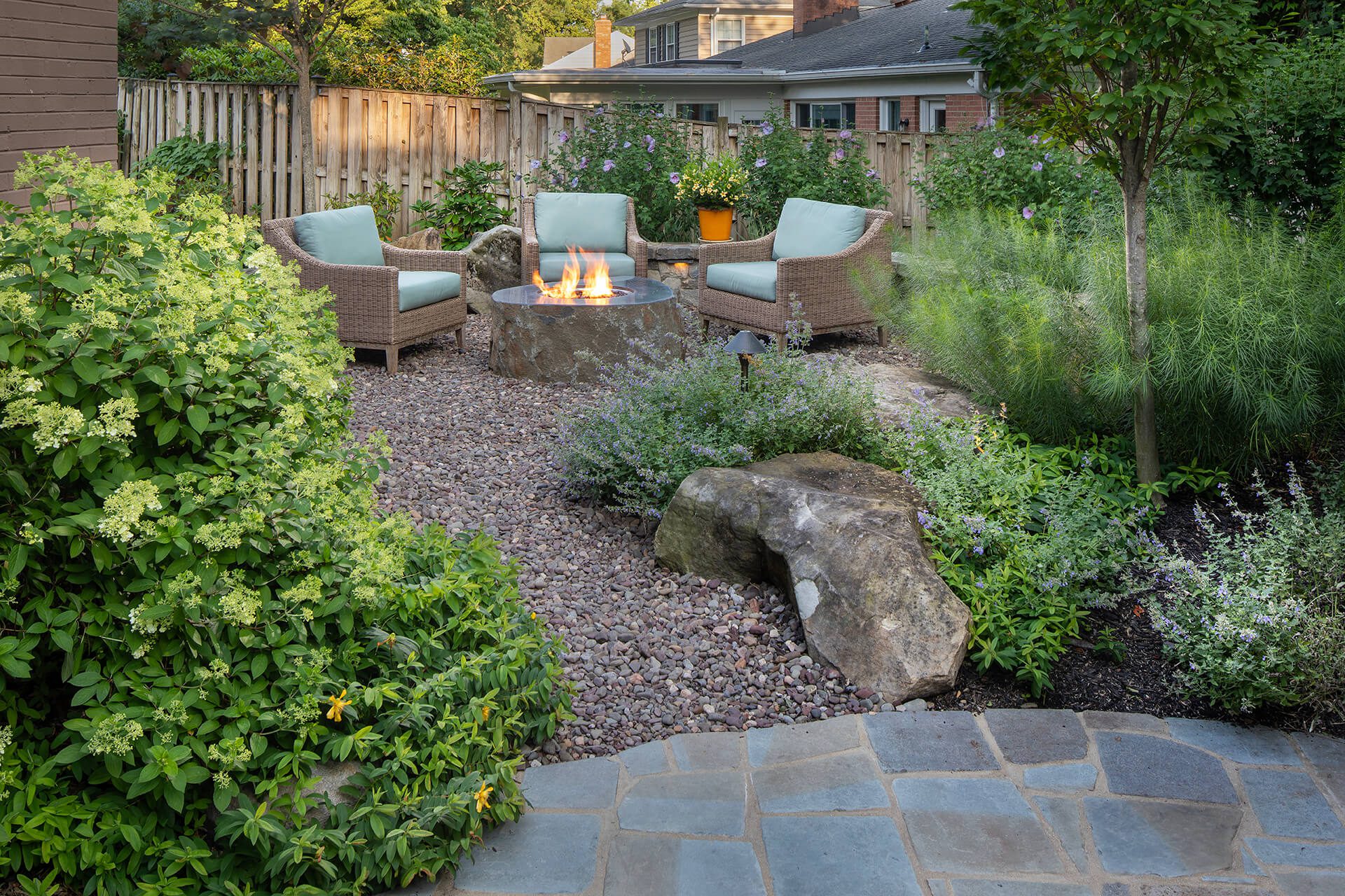 a patio firepit bordered by lush plantings