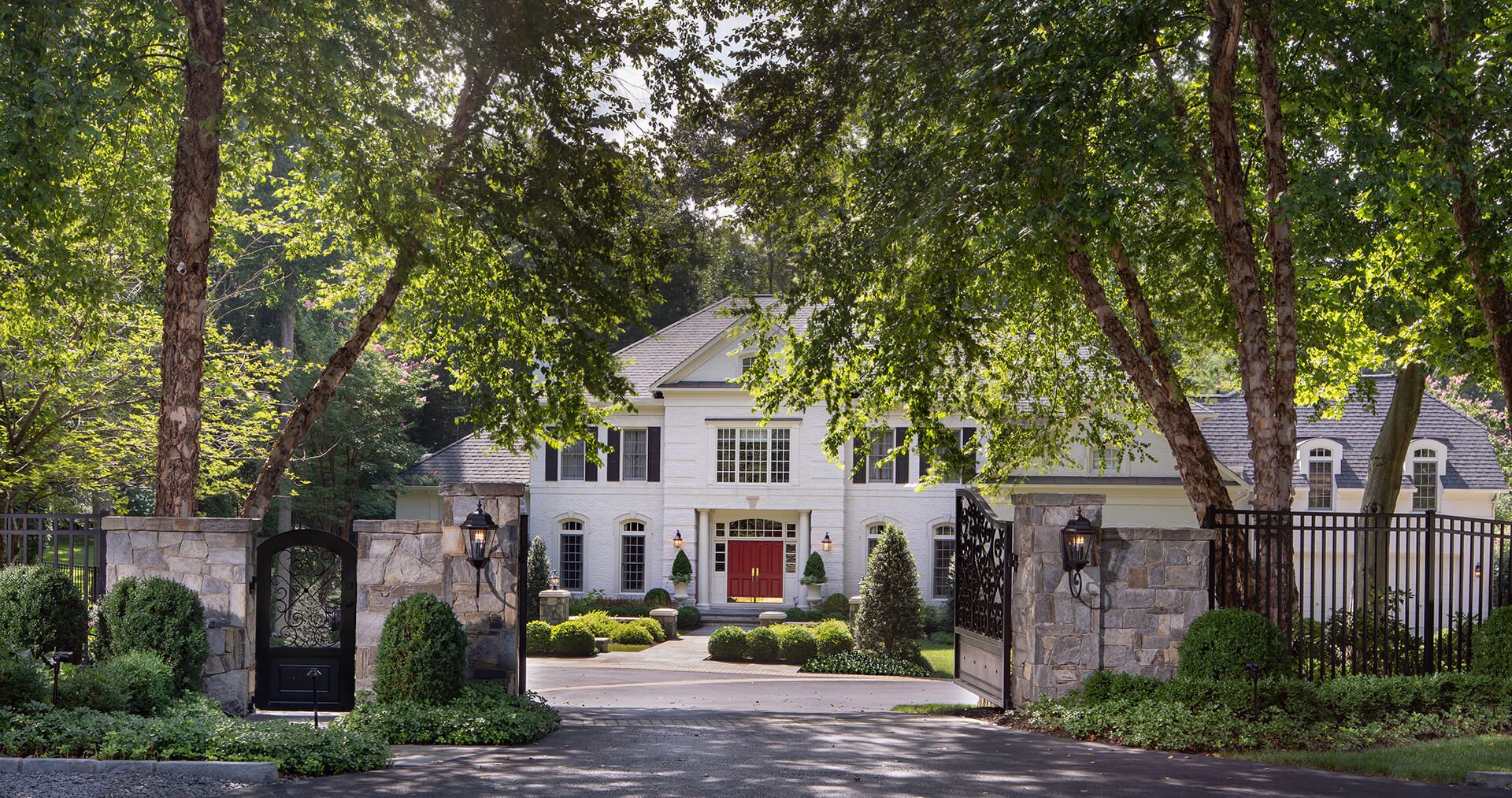 front yard design with privacy wall and custom designed iron driveway gate