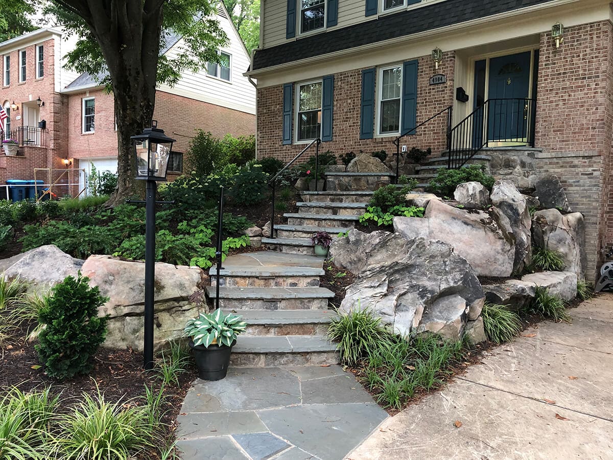 new stone retaining wall bordering driveway