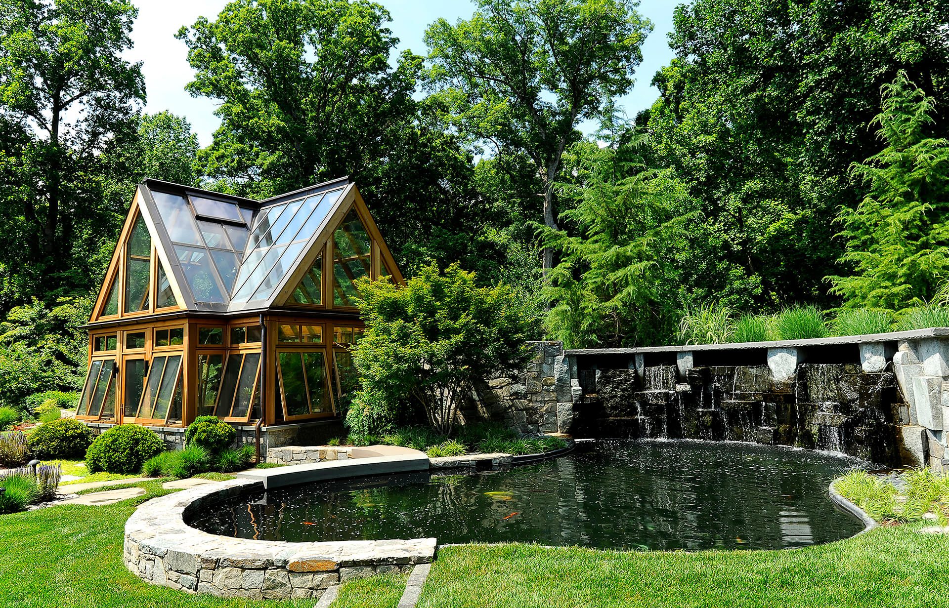 backyard pond with greenhouse and weeping wall