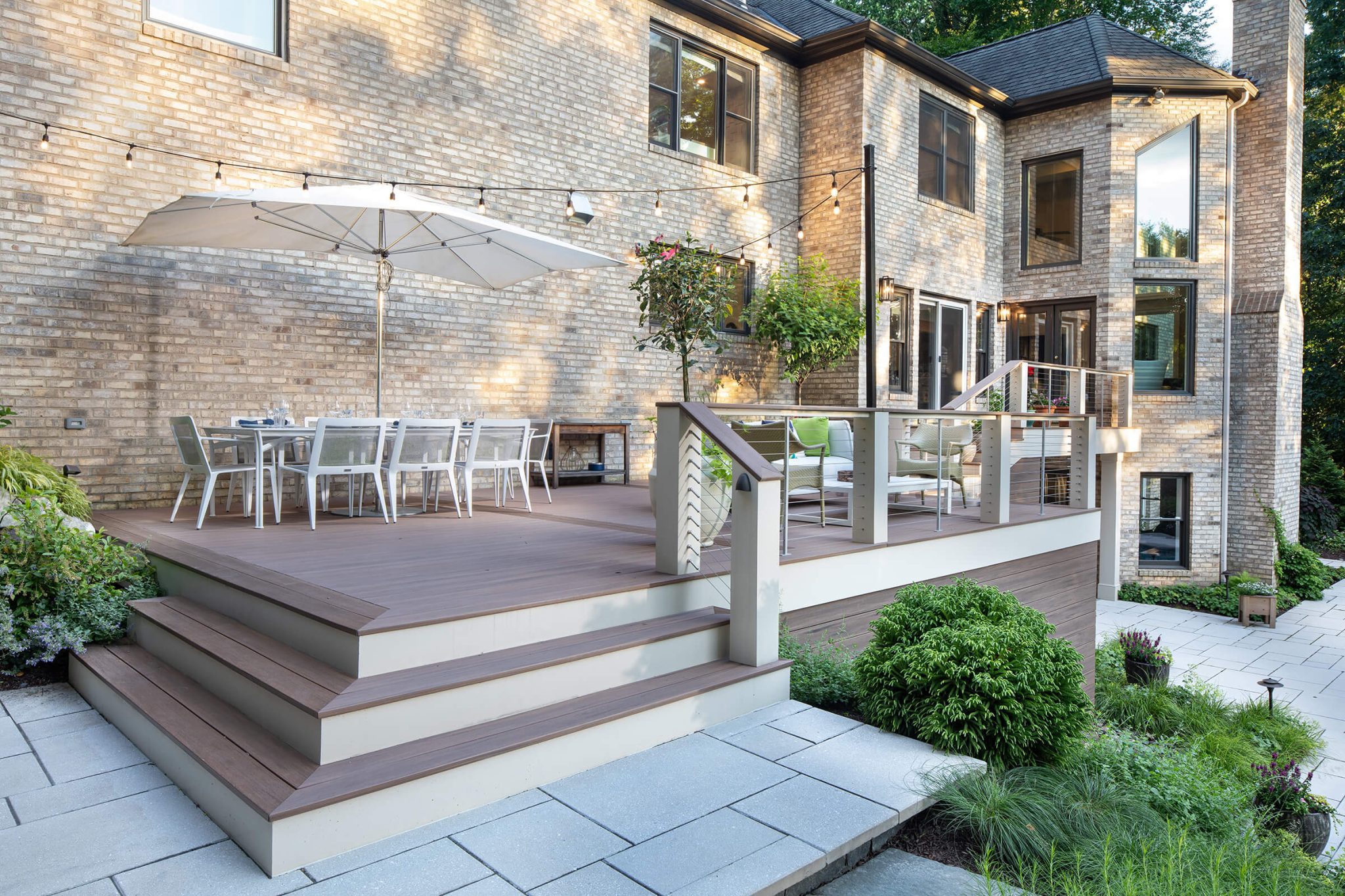 the modern deck steps down to a patio fire pit