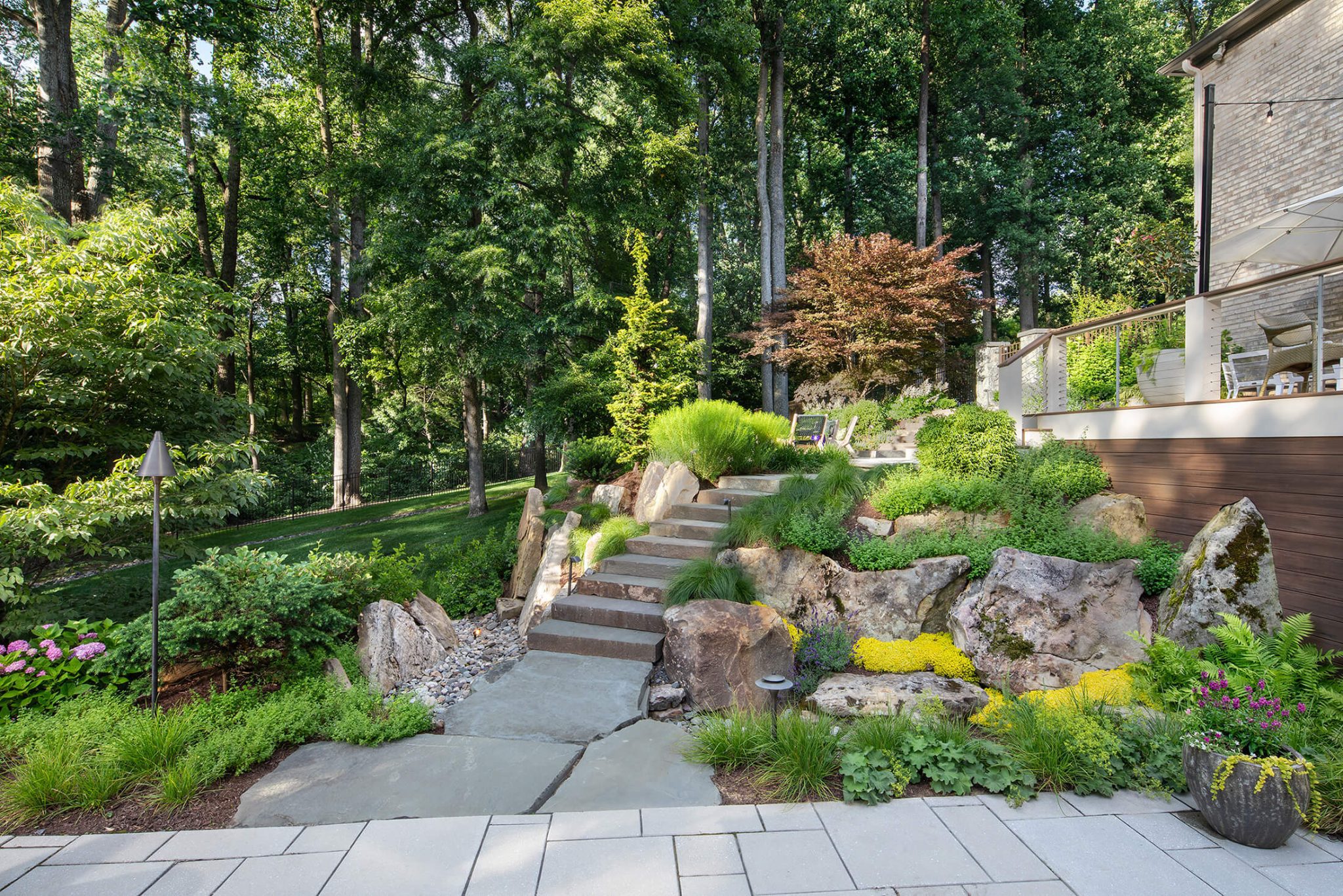 rough hewn stone steps lead down to the pool deck
